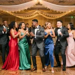 Groupe de mariés et invités dansant le kuduro lors d'une réception de mariage élégante en salle