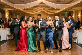 Groupe de mariés et invités dansant le kuduro lors d'une réception de mariage élégante en salle
