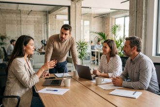 Équipe multiculturelle en réunion autour d'une table de bureau moderne, illustrant la diversité au travail
