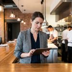 Femme d affaires vérifiant commandes sur tablette dans restaurant