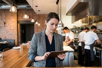 Femme d affaires vérifiant commandes sur tablette dans restaurant
