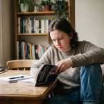 Jeune personne lisant un livre sur le filmmaking dans une cuisine